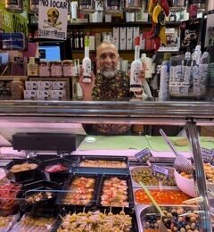 Local vendor showcasing olive oil, olives and gildas at La Bretxa market in San Sebastián
